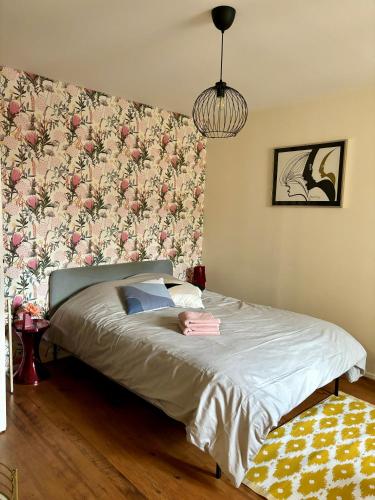 une chambre avec un lit avec un papier peint fleuri dans l'établissement Fleure de Ly / Superb studio flat in Old Town, à Metz