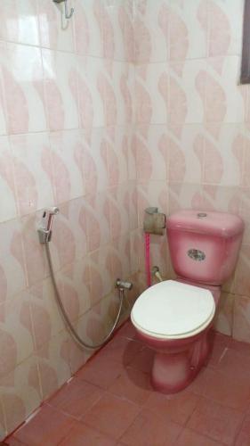 y baño con aseo rosa y ducha. en Ramya Villa, en Galle
