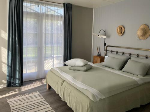 a bedroom with a large bed and a large window at Hotel Strandgaarden in Vesterø Havn