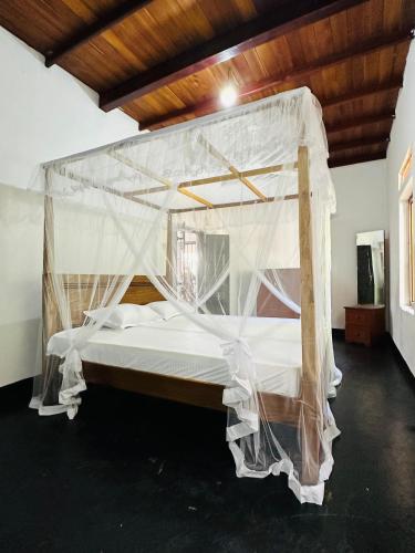 een slaapkamer met een bed bedekt met klamboes bij Villa Gihan in Hikkaduwa