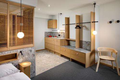 a bedroom with a bed and a desk and a kitchen at Palmiers by Fassbind in Lausanne