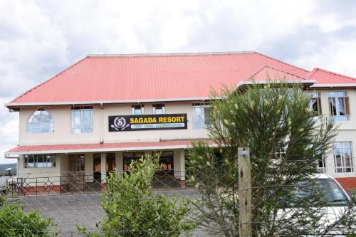 un edificio scolastico con un tetto rosso e una recinzione di Sagada Resort Lamuria a Lamuria