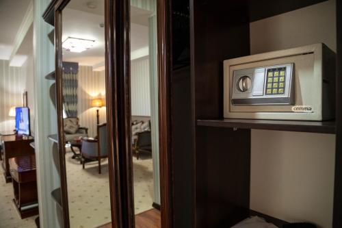 a microwave on a shelf in a hotel room at Zargaron Plaza in Bukhara
