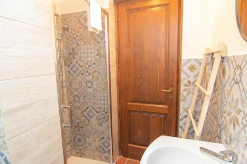 a bathroom with a wooden door and a sink at La Locanda Di Giada in Pisa