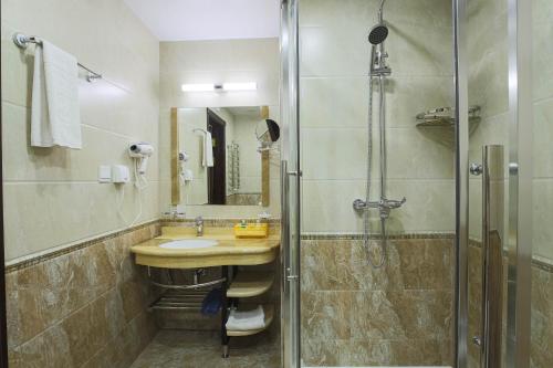 a bathroom with a sink and a shower at Zargaron Plaza in Bukhara