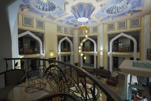 a lobby with a blue and white ceiling and a staircase at Zargaron Plaza in Bukhara
