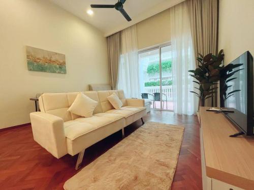 een woonkamer met een witte bank en een televisie bij Strait Quay Marina Cozy Suite with Bathtub by Uptrend Home Management in Tanjong Tokong