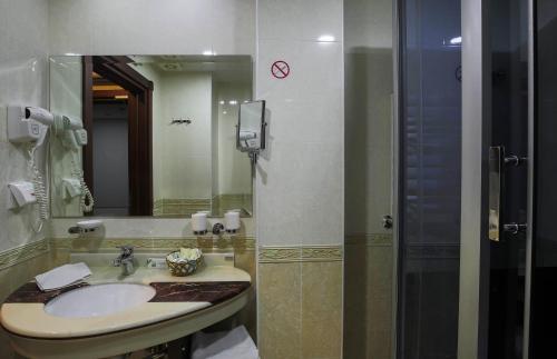 a bathroom with a sink and a mirror at Zargaron Plaza in Bukhara