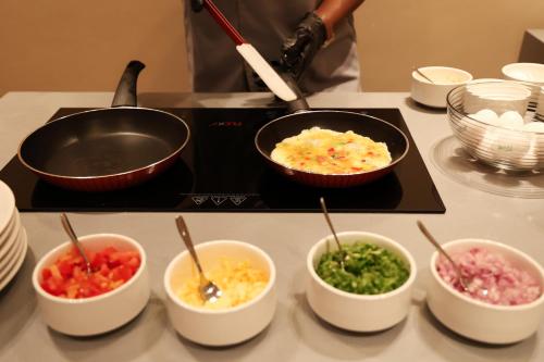 a counter with bowls of food on a stove at شقق الماسة التاج للشقق الفندقية in Hail