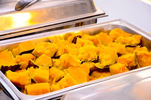 a metal pan filled with food in a cafeteria at Peniel Beach Hotel in Entebbe