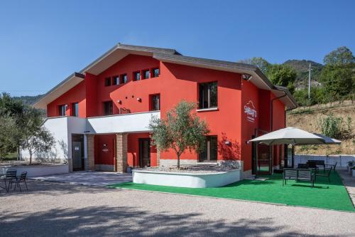 un bâtiment rouge avec un arbre dans une cour dans l'établissement Sanbarto la Casa del Borgo, 