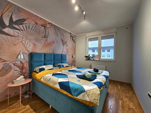 Turquoise Apartment (Private Garage) في نوفي ساد: غرفة نوم بسرير ازرق مع لوحة على الحائط