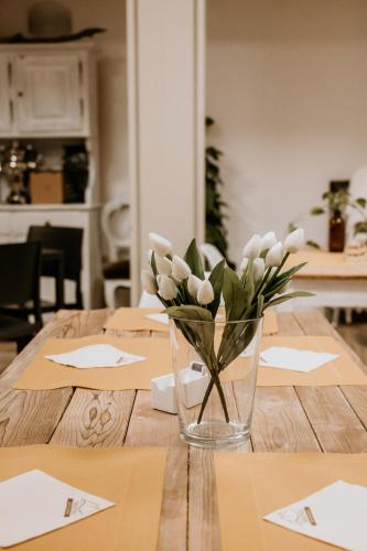 a vase of white flowers sitting on a wooden table at Hotel Venezia in Trento