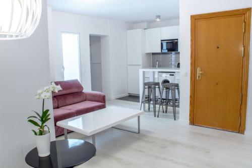 a living room with a red chair and a table at Santa Cruz Apartments in Málaga