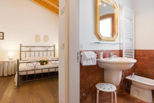 un bagno con lavandino, servizi igienici e un letto di Al Piccolo Clarin a Mestre