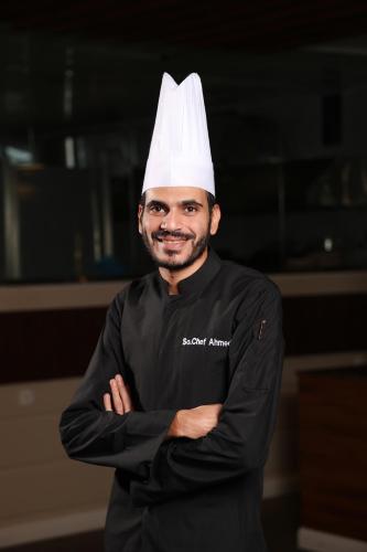 a man wearing a chef hat with his arms crossed at شقق الماسة التاج للشقق الفندقية in Hail