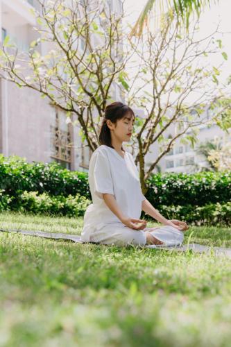 a woman sitting on the grass in the grass at Wyndham Grand Phu Quoc in Phu Quoc