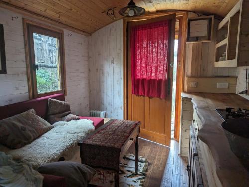uma sala de estar com um sofá e uma janela em roulotte à la mauvaise herbe em Barjols