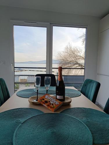 a table with a bottle of wine and two glasses at Wilcza Przystań in Borzygniew