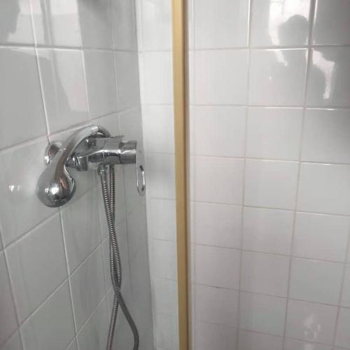 een douche met een douchekop in de badkamer bij 12 rue des Ormeaux in Rennes