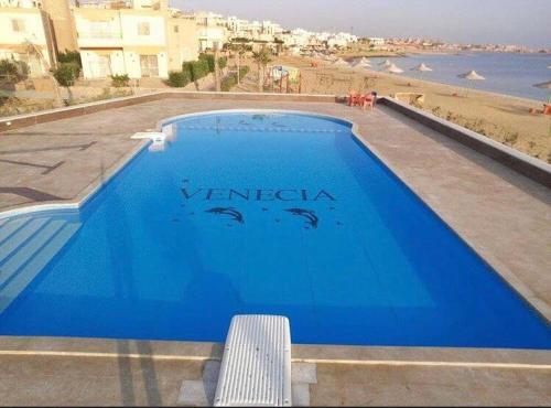 a blue swimming pool with a view of the beach at Cozy Villa Venice Ain Sokhna in Ain Sokhna