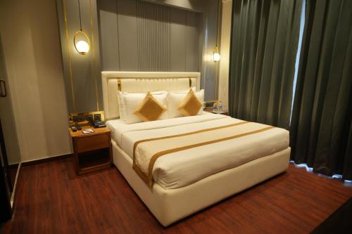 a hotel room with a large bed and a table at Comfort Inn Karnal in Taraori