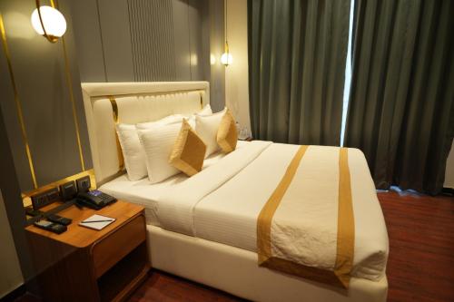 a hotel room with a bed and a table with a night stand at Comfort Inn Karnal in Taraori