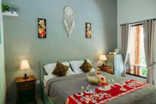 un dormitorio con una cama con un animal de peluche en Kinton Guesthouse, en Nusa Penida