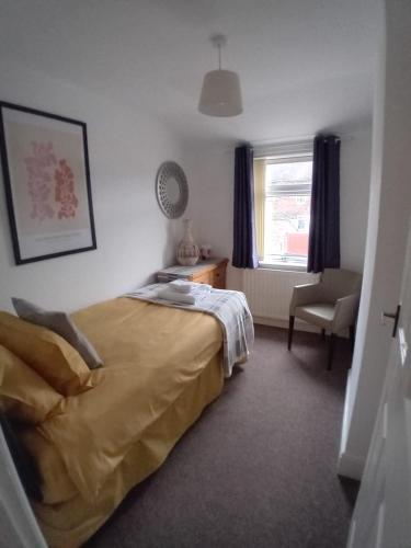 a bedroom with a bed and a chair and a window at Colville House in Lincolnshire