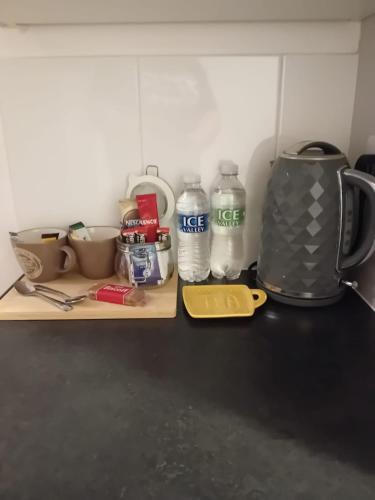 a kitchen counter with a coffee maker and bottles of water at Colville House in Lincolnshire