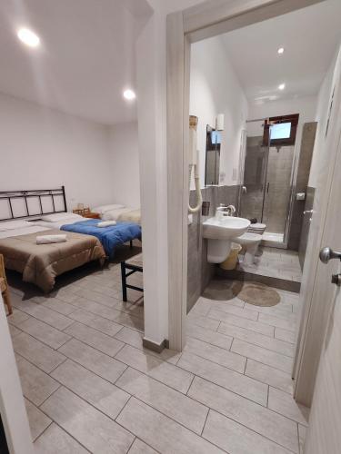 1 dormitorio con baño con cama y lavamanos en Hotel Faraglione, en Vulcano