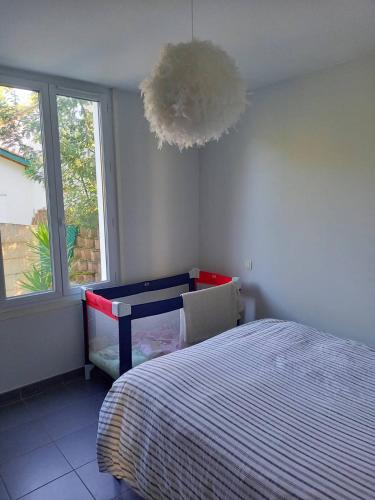 une chambre avec un lit, un bureau et une fenêtre dans l'établissement CAPBRETON -Appartement rez de jardin quartier proche centre et plages 5 pers, à Capbreton