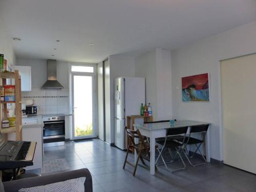 - une cuisine avec une table et des chaises dans l'établissement CAPBRETON -Appartement rez de jardin quartier proche centre et plages 5 pers, à Capbreton