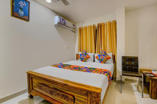 a bedroom with a large bed and a desk at FabExpress Rithun Residency in Bangalore