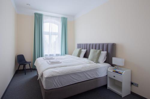 a bedroom with a large bed and a window at Laima V. Apartments in Riga