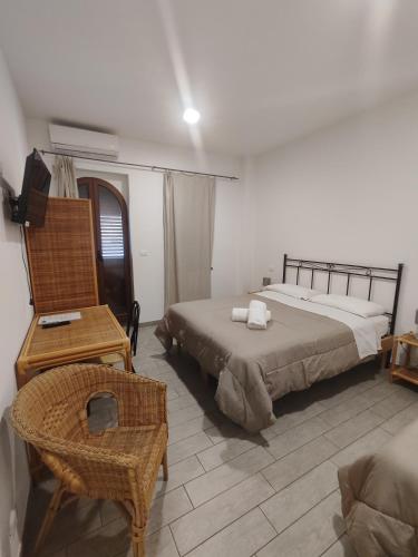 Hotel Faraglione في فولكانو: غرفة نوم بسريرين وكرسي ومكتب