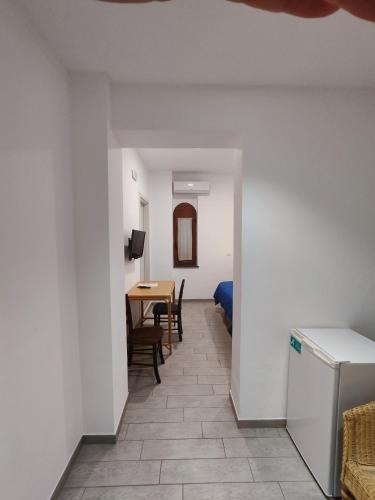 a hallway with a kitchen and a dining room with a table at Hotel Faraglione in Vulcano