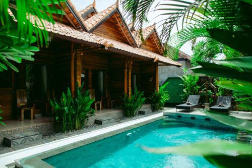 a house with a swimming pool in front of a house at Kinton Guesthouse in Nusa Penida