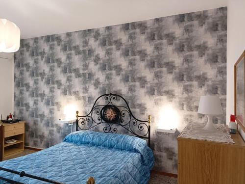 - une chambre avec un lit bleu et un mur gris dans l'établissement Domus Stadio, à Pescara