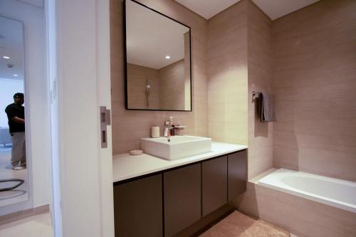 a bathroom with a sink and a mirror and a tub at 40 Minutes drive to Burj Khalifa in Sharjah