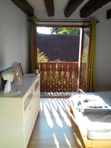 - une chambre avec un lit et un balcon avec une fenêtre dans l'établissement Au calme à 5min d'Annecy et du lac, à Seynod