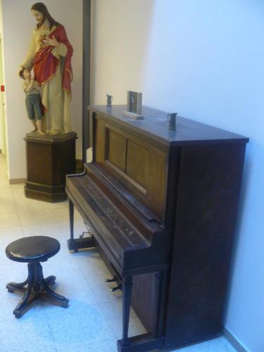 a piano in a room with a statue of a woman at Casa Religiosa Di Ospitalità Nazareno in Spoleto