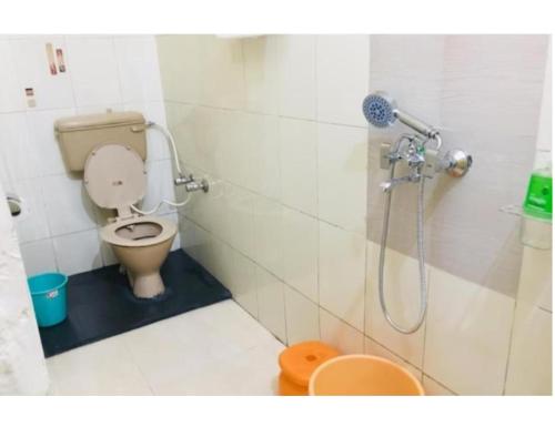 La petite salle de bains est pourvue d'une douche et de toilettes. dans l'établissement Hotel Anmol & Restaurant, Rudraprayag, à Rudraprayāg