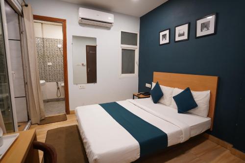 een slaapkamer met een bed met een blauwe muur bij Hotel Lyf Corporate Suites - Peera Garhi in New Delhi