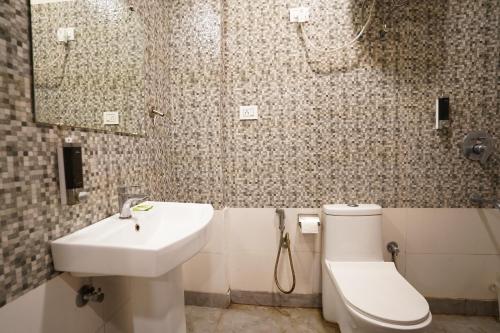 Łazienka z białą toaletą i umywalką w obiekcie Hotel Lyf Corporate Suites - Peera Garhi w Nowym Delhi