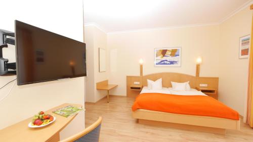 a hotel room with a bed and a flat screen tv at Hotel garni Arte Vita in Heringsdorf