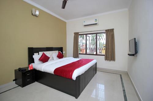 a bedroom with a large bed with a red blanket at Hotel Sai Leela in Puri