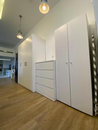 a large room with white cabinets and a hardwood floor at Schöne, moderne Wohnung mit großzügiger Terasse in Essen