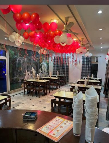 a restaurant with red and white balloons hanging from the ceiling at Shri Ram Hotel in Ayodhya