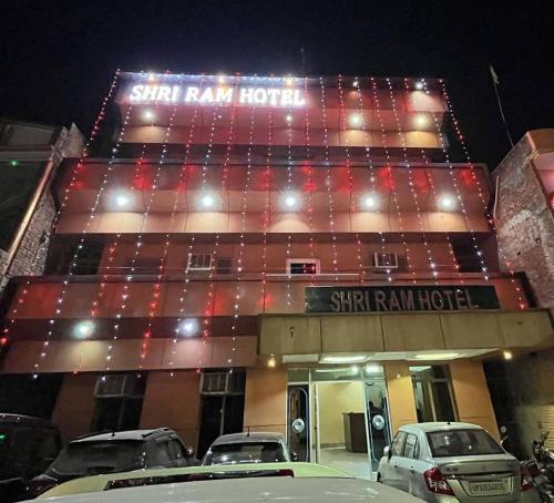 a star rain hotel with cars parked in front of it at Shri Ram Hotel in Ayodhya